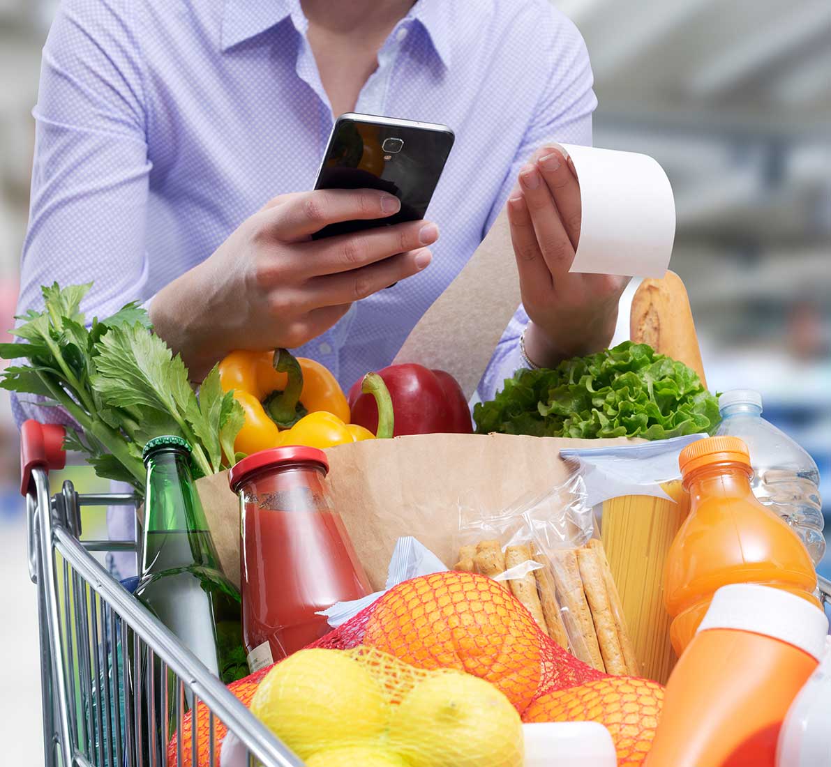 Woman checking the grocery receipt using her smartphone